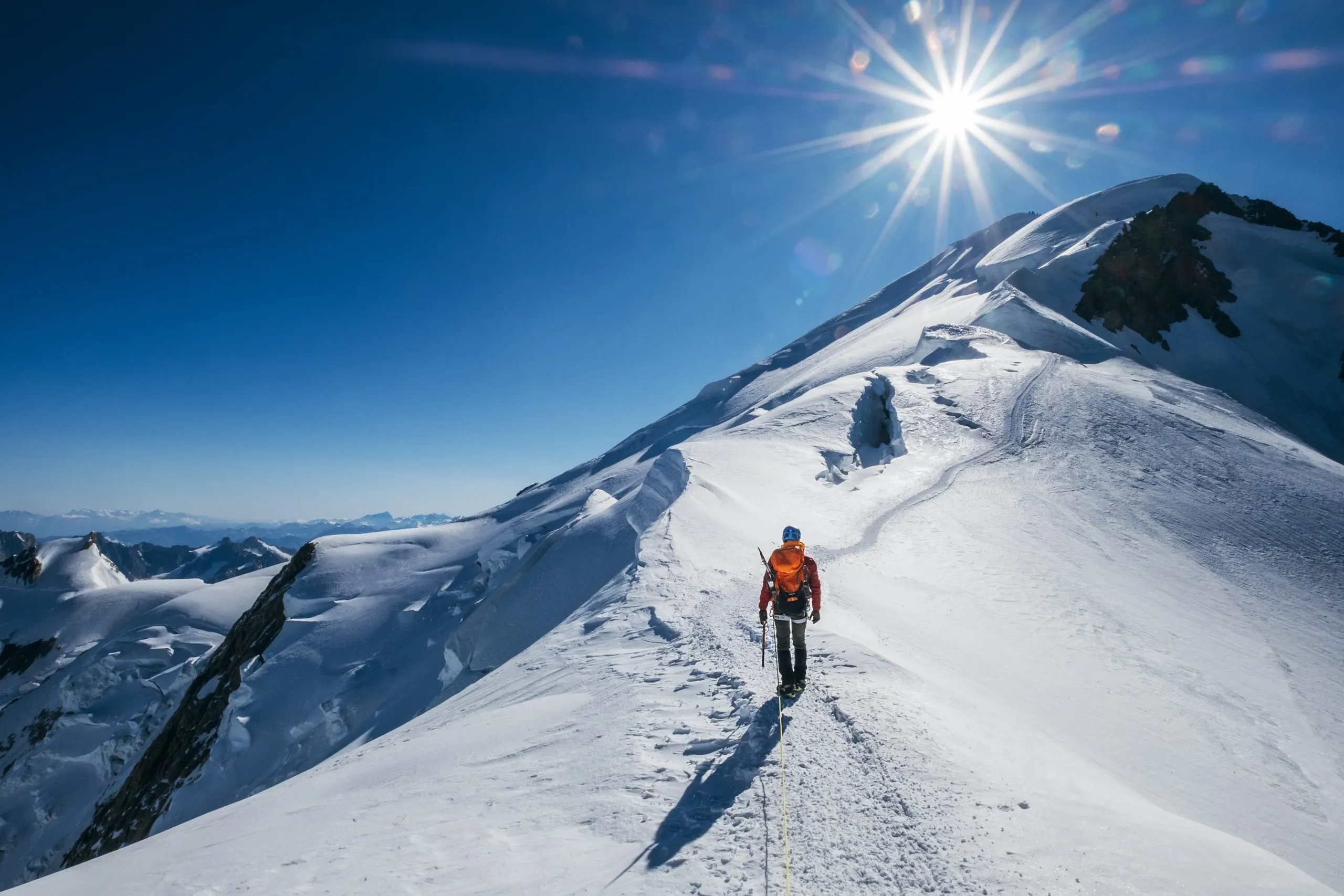 climber below peak of mont blanc