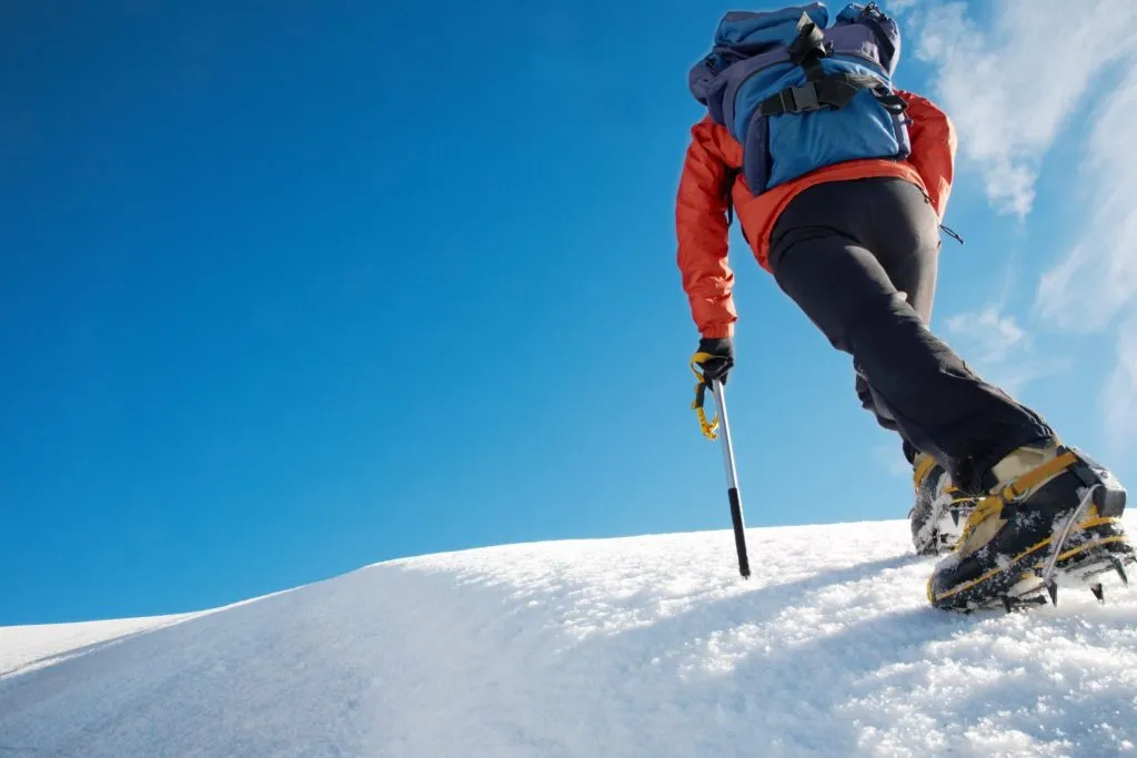 alpinista solitario escalando una cresta nevada