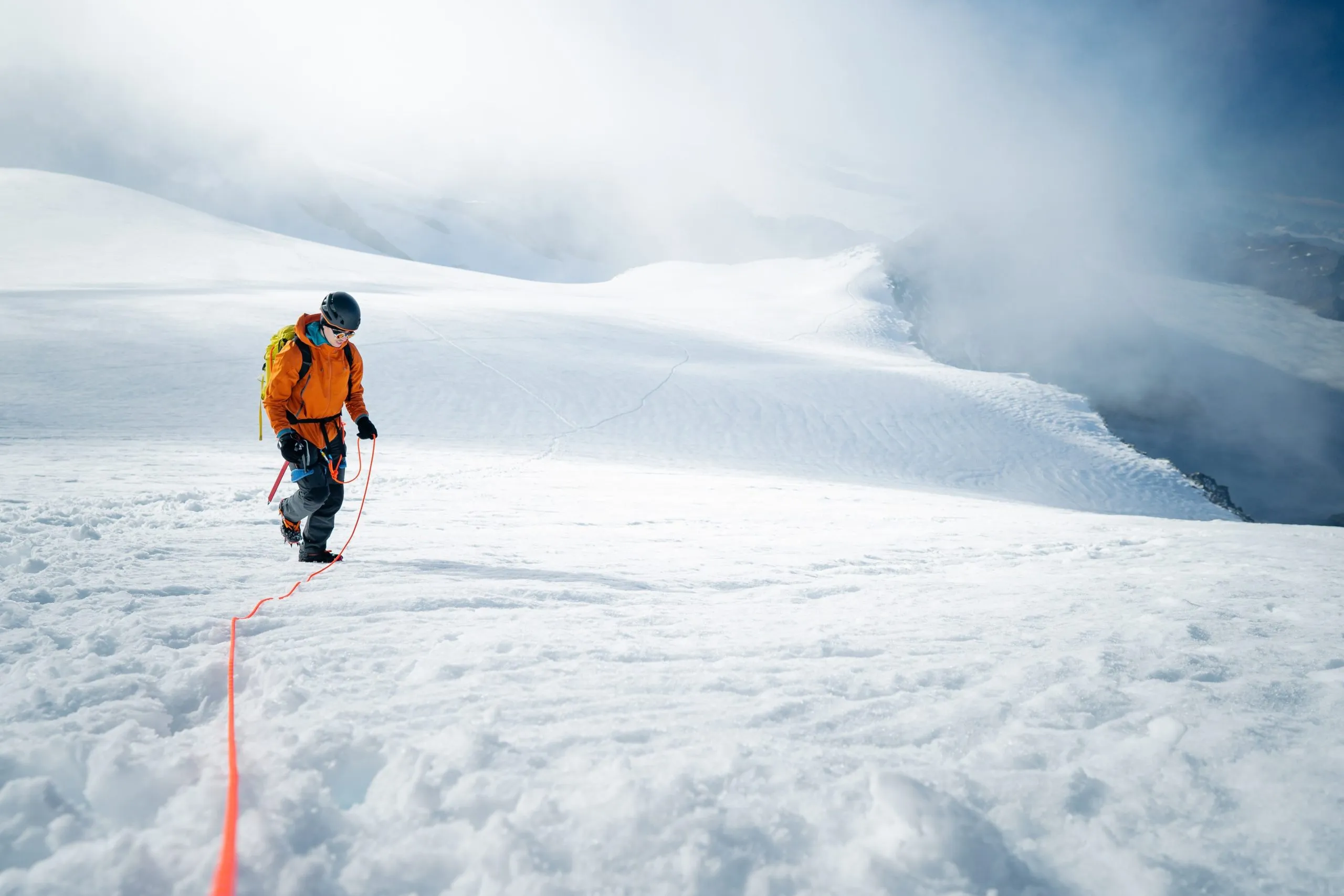 mountaineer walking uphill a glacier