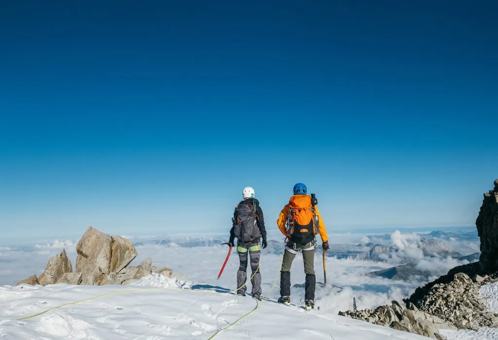 zwei bergsteiger bewundern die aussicht auf den erklommenen mont blanc
